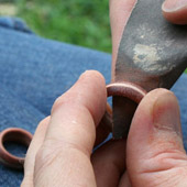 Smoothing wooden ring with sandpaper